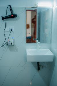 a white bathroom with a sink and a mirror at Diyana Cottage in Sigiriya +28 photos