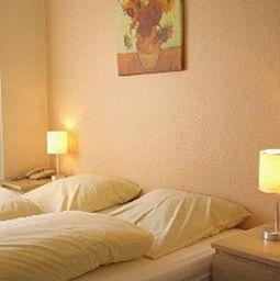 a bedroom with two beds and two lamps on tables at Hotel an der Marktkirche in Hannover