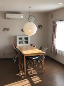 a dining room table with chairs and a light fixture at Cozy Penguin House Bibai in Bibai