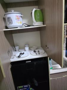 a kitchen with a stove and a toaster on a shelf at nicecondotel in Manila +5 photos