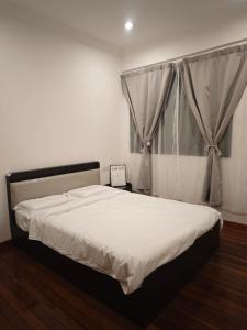 a bedroom with a large white bed with a window at Pasadena Home in Tawau +3 photos