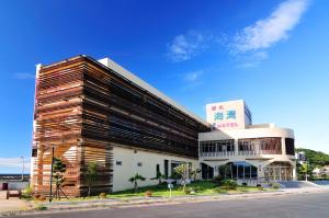 duży drewniany budynek po stronie ulicy w obiekcie JinShan Sakura Bay Hot Spring Hotel w mieście Jinshan