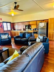 a living room with leather couches and a kitchen at Bermagui Bay Beach House 2, Wonderful Beachside Location, Pet Friendly in Bermagui +24 photos