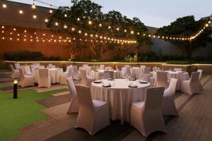 a marquee with white tables and chairs and lights at Aloft by Marriott Dubai Creek in Dubai +103 photos