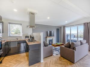 a kitchen and living room with a couch and a table at Billy Goat Lodge in Crossway Green