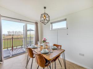 a dining room with a table and chairs and a large window at Billy Goat Lodge in Crossway Green