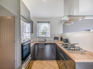 a kitchen with a sink and a stove top oven at Billy Goat Lodge in Crossway Green