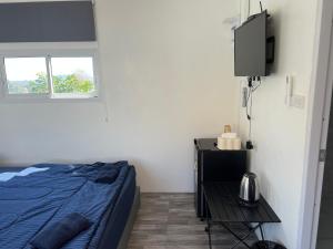 a bedroom with a bed and a tv and a table at พิงภู ไทรโยค กาญจนบุรี in Sai Yok +51 photos