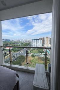 a bedroom with a large window with a view of a city at LCONDOTEL Imperial Plaza Residences in Manila
