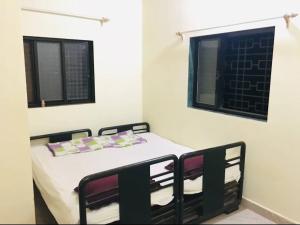 a small room with a bed and two windows at Homestay, Villa in Diveagar in Diveagar