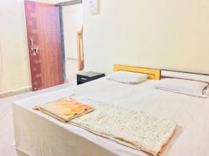 a white bed with a blanket on top of it at Homestay, Villa in Diveagar in Diveagar