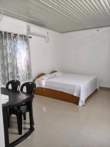 a bedroom with a bed and a table and chairs at Lagoon lake view in Kollam