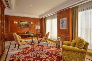 a living room with a couch and chairs and a desk at Le Meridien Al Khobar in Al Khobar