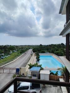 a view of a pool from the balcony of a building at Central City Condo Getaway in Gun-ob