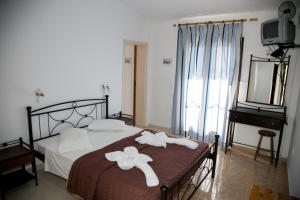 a bedroom with a bed with towels on it at Kefalonia Beach Hotel & Bungalows in Lixouri