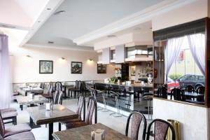 a restaurant with tables and chairs and a car in the window at Hotel Alcomar in Gijón