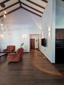 a living room with two chairs and a tv at Villa Sukka in Tangalle