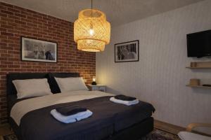 a bedroom with a bed with a brick wall at Studio apartman Relax in Đakovo