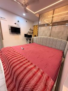 a bedroom with a red blanket on the back of a couch at Chill Vibes in Visakhapatnam