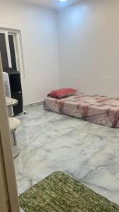 a white room with a bed and a green rug at Chill Vibes in Visakhapatnam