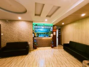 a lobby with two black couches and christmas trees at Hotel Best Inn in Darjeeling