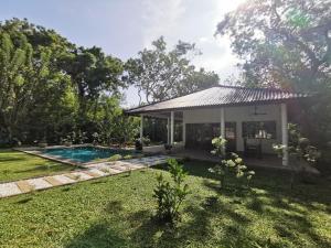 a house with a swimming pool in a yard at Villa Sukka in Tangalle