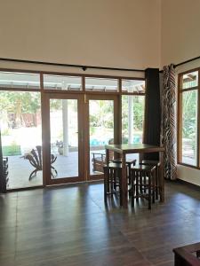 a dining room with a table and chairs and sliding glass doors at Villa Sukka in Tangalle