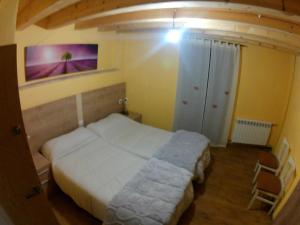 a bedroom with a white bed in a room at Cal Fuster I in Todolella