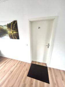 ein Zimmer mit einer weißen Tür und einem Gemälde an der Wand in der Unterkunft SmartStay Wuppertal Self Check-in Parking Budget Hotel in Wuppertal