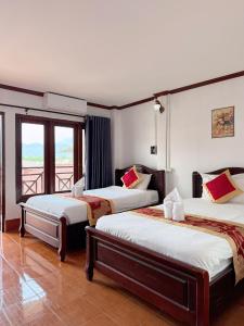a hotel room with two beds and a balcony at Vang Vieng Sisavang Hotel in Vang Vieng +137 photos