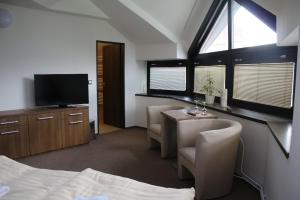 a bedroom with a bed and a table and a tv at Hotel Pod Radnicí in Šumperk
