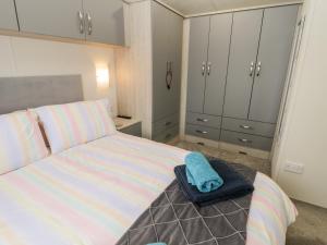 a bedroom with a bed with a blue towel on it at Lazy Daze in Bridlington