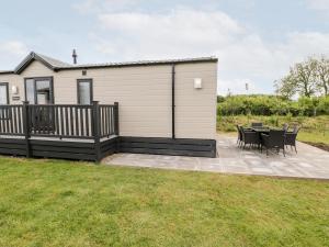 a house with a deck with a table and chairs at Lazy Daze in Bridlington