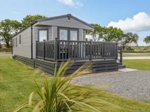 a tiny house with a porch and a deck at Happy Daze in Bridlington