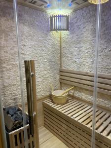 a sauna with a tub and a bucket in a room at Nuit Détente Rodez in Rodez