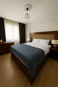 a bedroom with a large bed with a blue blanket at Leopard edirne in Edirne