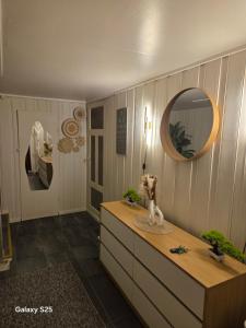 a room with a dresser and a mirror on the wall at Auroraheim in Gryllefjord