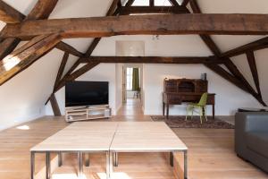 uma sala de estar com uma mesa e uma televisão em Hof Van Spanje em Gent