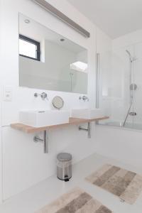 uma casa de banho branca com um lavatório e um chuveiro em Hof Van Spanje em Gent