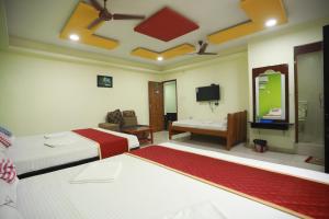 a hotel room with two beds and a television at Hotel Madurai Comforts in Madurai +51 photos