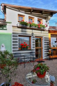 ein Haus mit einer Terrasse mit Blumen im Fenster in der Unterkunft Apartments Emma in Červená Voda