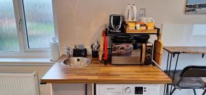 a kitchen counter with a sink and a microwave at CeolMara in Ullapool