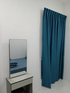 a mirror on a table next to a blue curtain at D'Tarbiyyah Homestay in Labu
