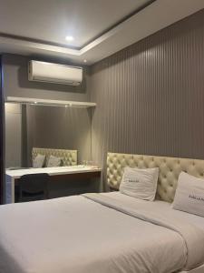 a bedroom with a large bed and a desk at Barkah inn in Kannur