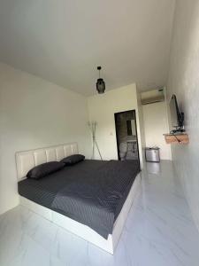 a bedroom with a large bed in a white room at พิงภู ไทรโยค กาญจนบุรี in Sai Yok