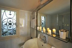 łazienka z umywalką, oknem i świecami w obiekcie Villa Lucia Varenna w mieście Varenna