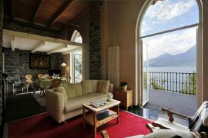 sala de estar con sofá y ventana grande en Villa Lucia Varenna, en Varenna