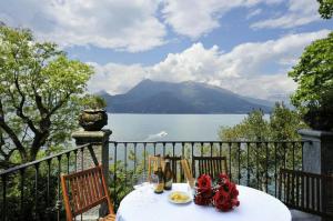 stół z kwiatami na balkonie z widokiem na jezioro w obiekcie Villa Lucia Varenna w mieście Varenna