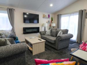 un soggiorno con due divani e una TV di Brighter Daze a Bridlington