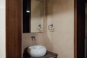 a bathroom with a white sink and a mirror at Capetown Shaadows in Igatpuri +25 photos